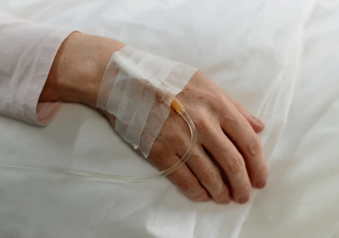 Kroplówki witaminowe Siemiatycze: dłoń z podłączoną kroplówką w spokojnym kadrze